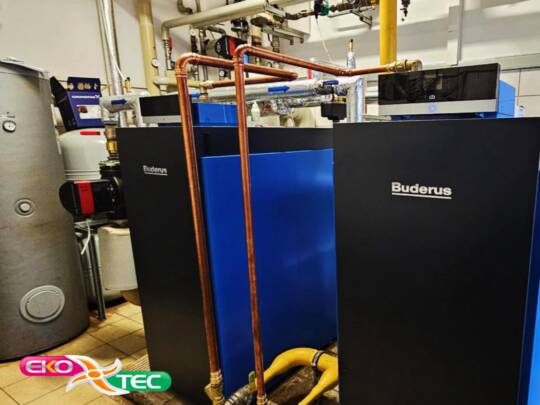 Industrial boiler room with Buderus units and copper piping installation.